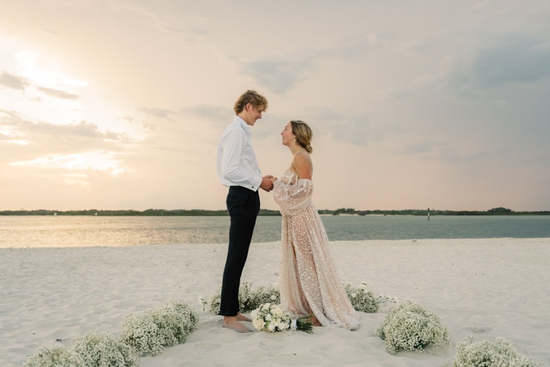 bride and groom exchange vows on the beach