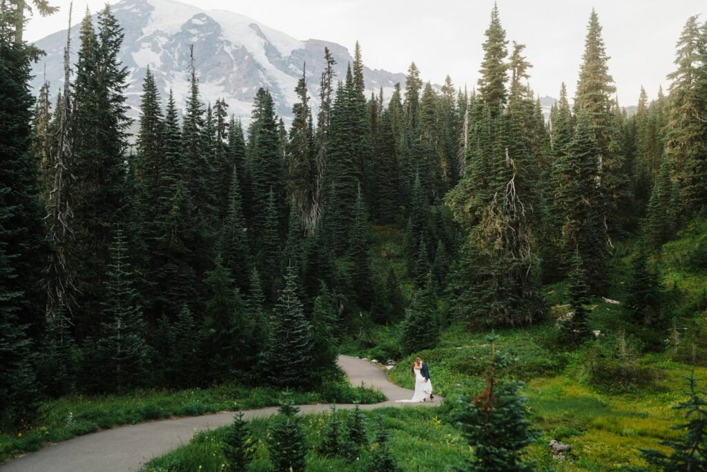 Bride and groom walk on hiking trail in Mt. Rainier National Park