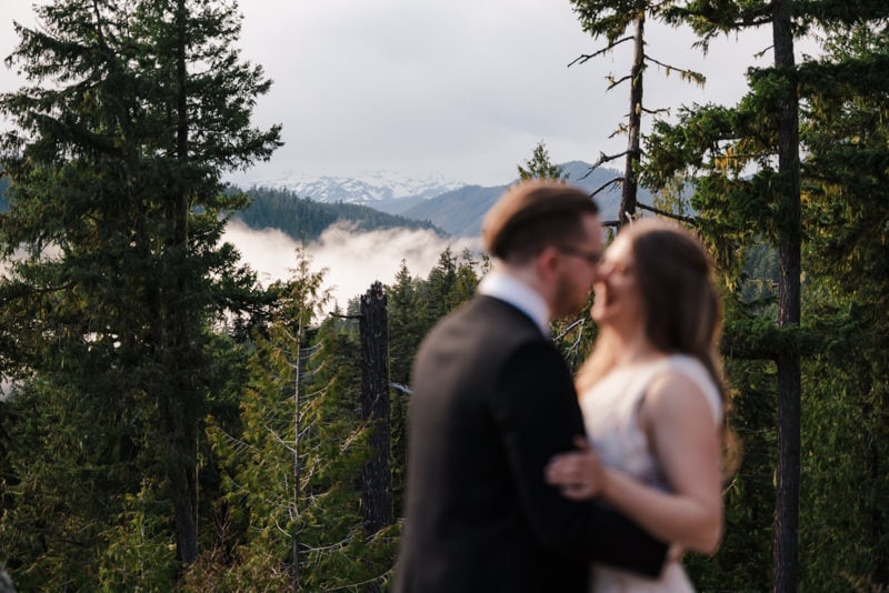 cloudy view of mt. rainier behind bride and groom