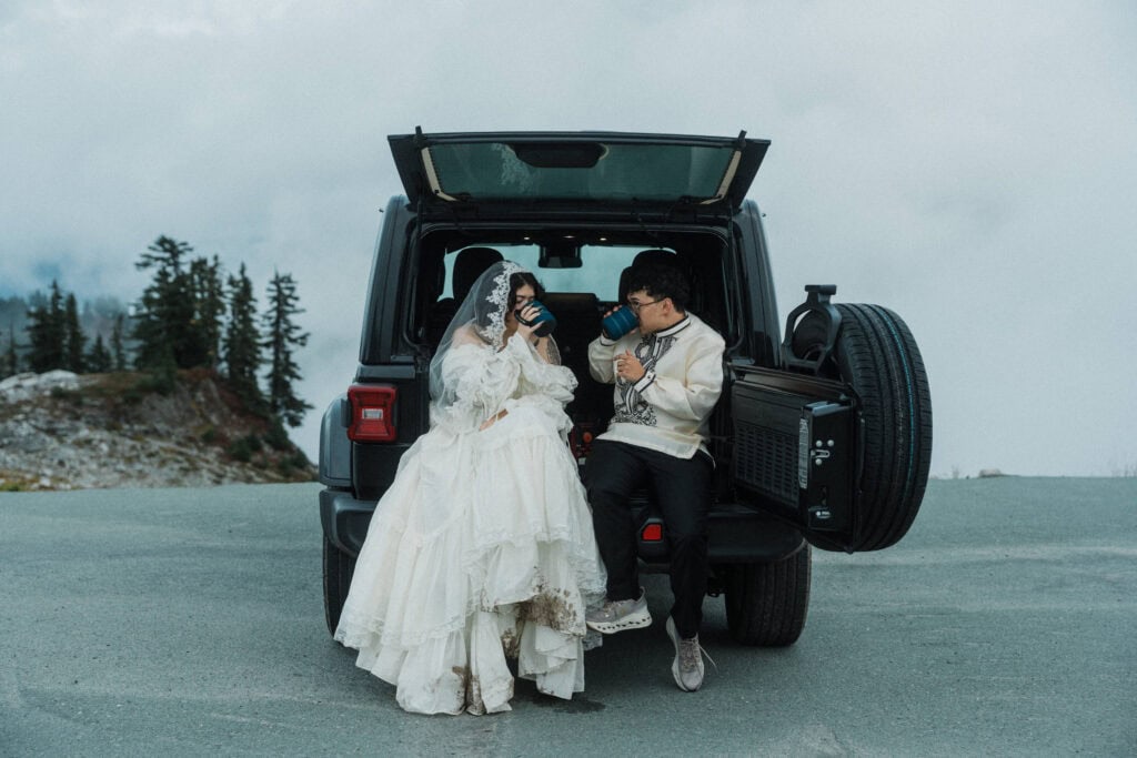 elopement couple sitting at the back of their jeep and sipping coffee