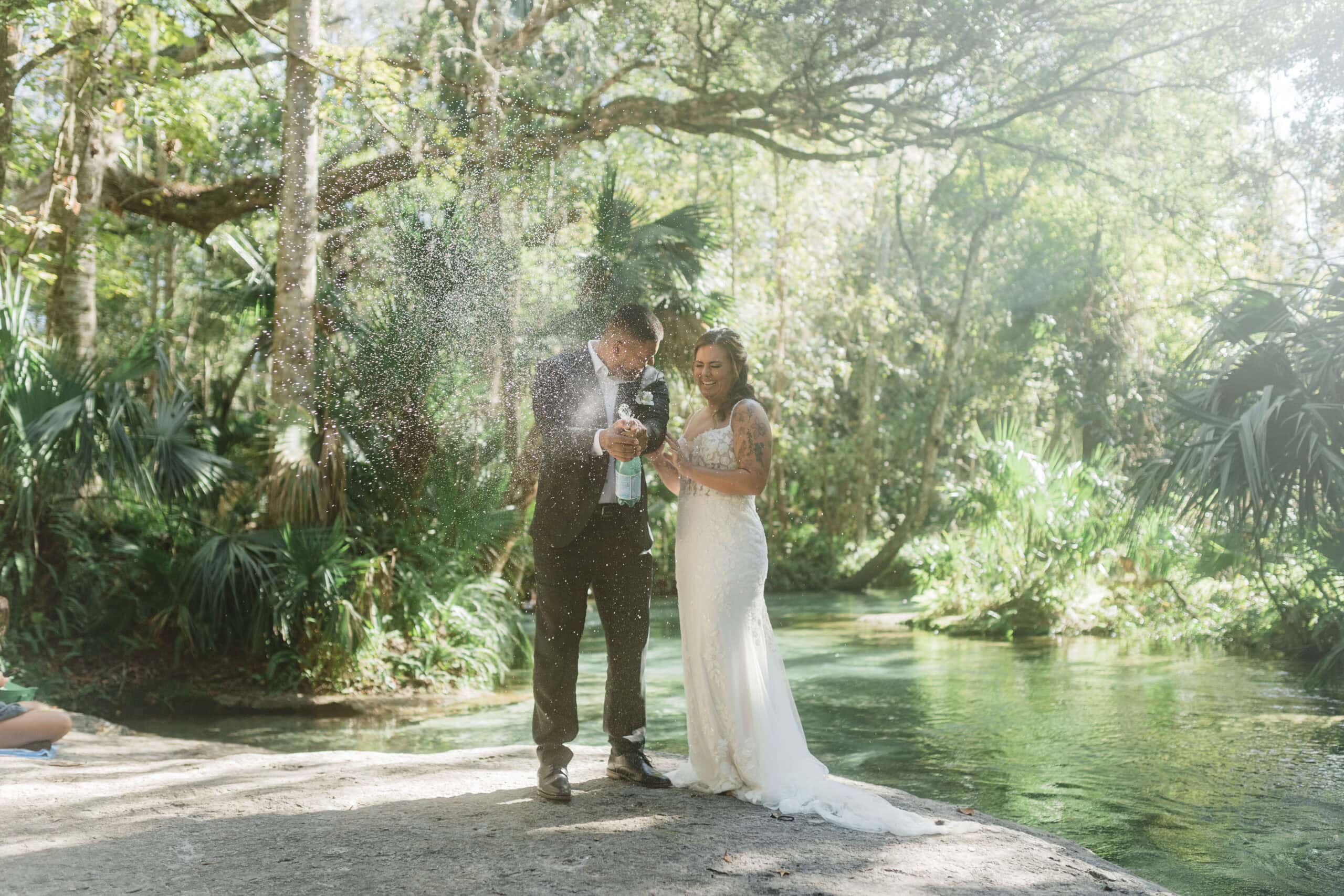 bride and groom popping champagne during their florida springs elopement