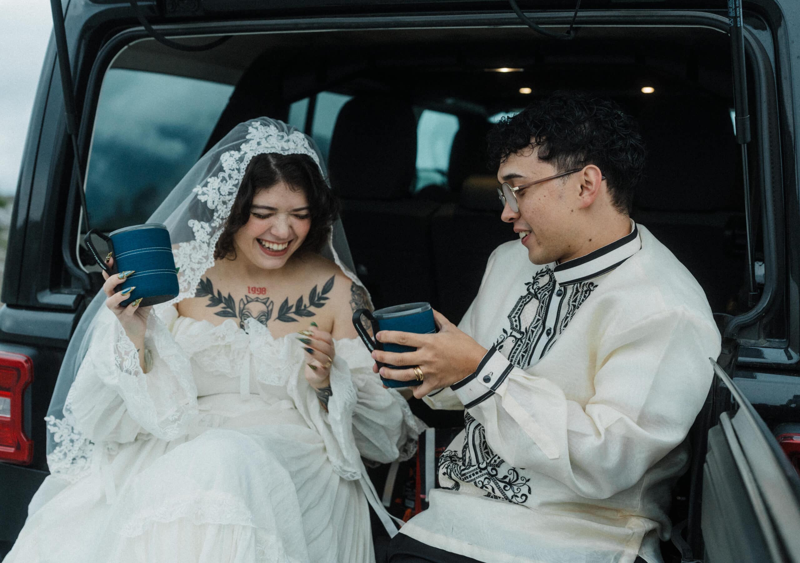 elopement couple drinking coffee at the back of their jeep during their adventure elopement in north cascades