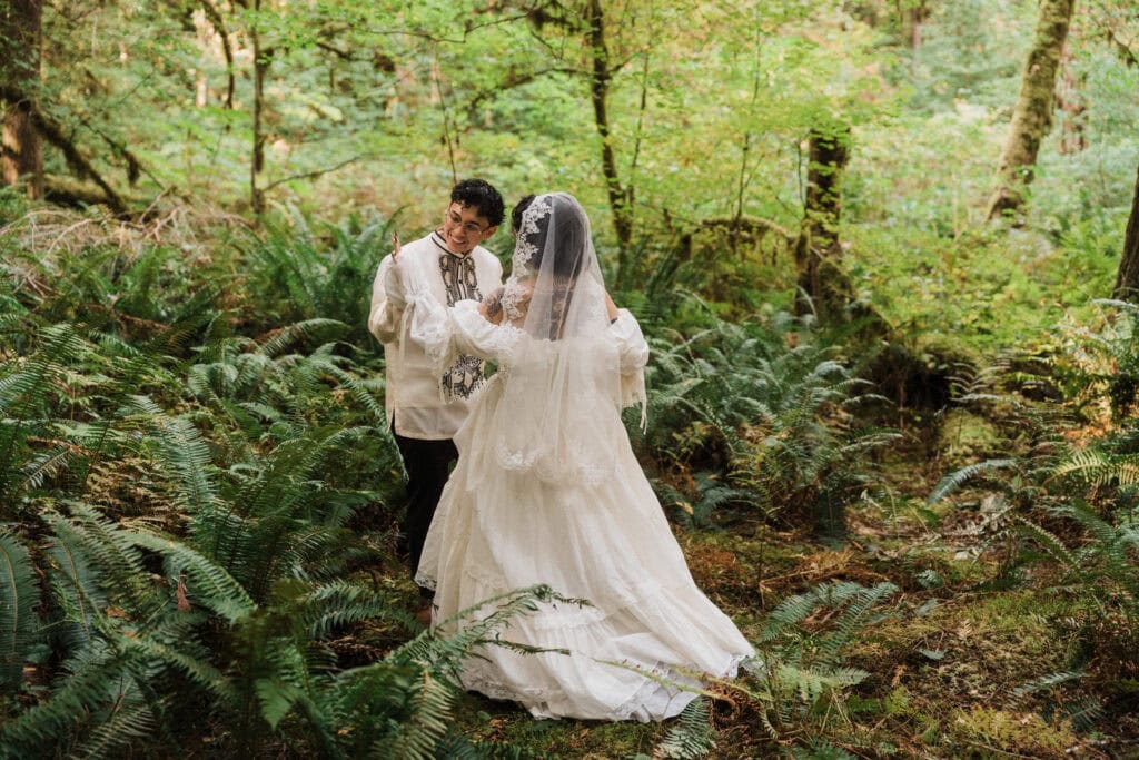 elopement couple first look surrounded by lush green ferns during their north cascades elopement
