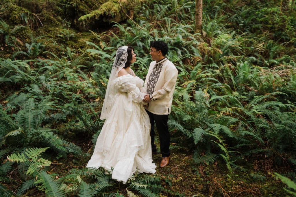 elopement couple first look surrounded by lush green ferns during their north cascades elopement