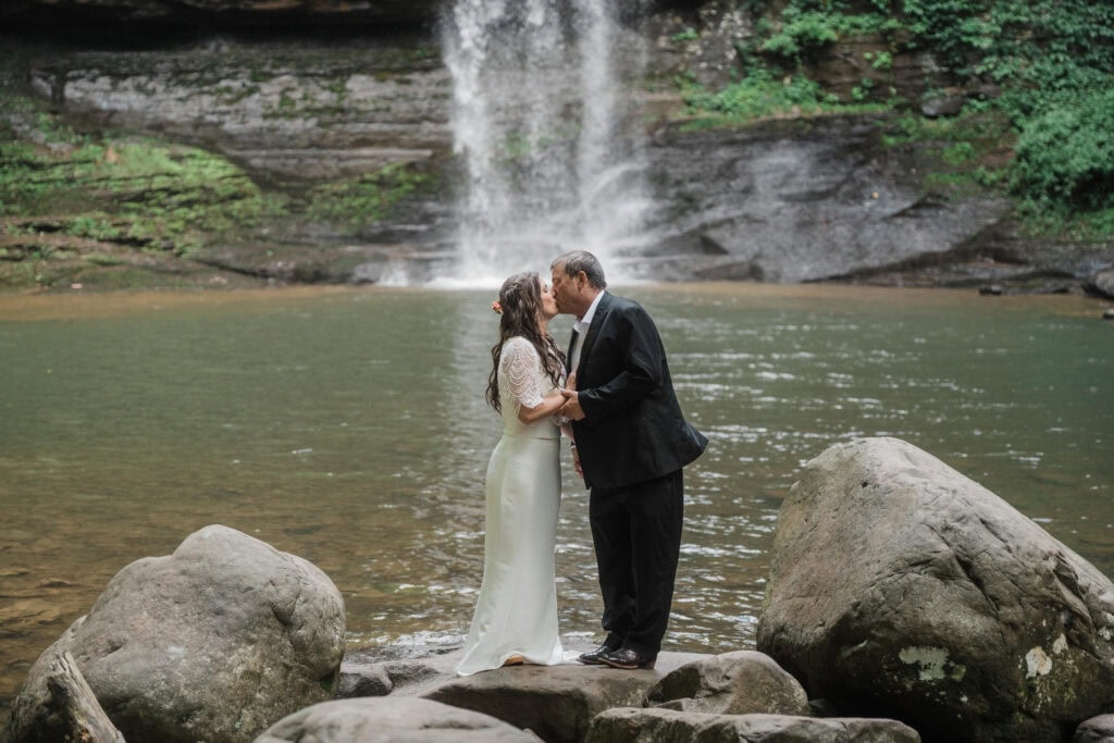 elopement couple kissing at a waterfall during a cloudland canyon elopement