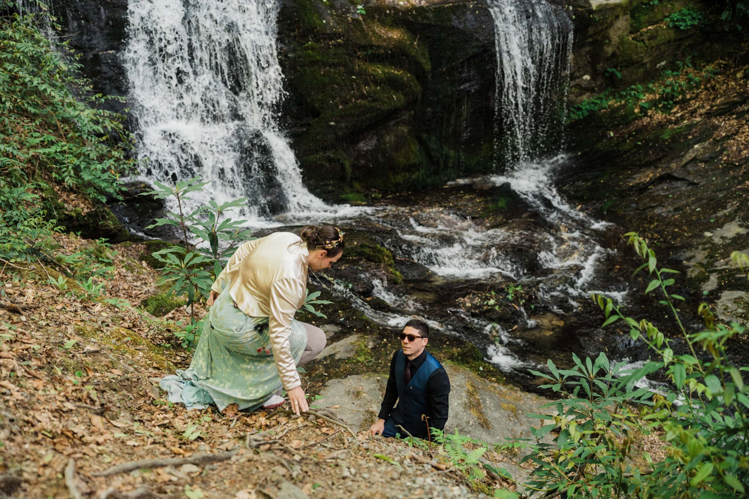 couple exchanging private vows in front of a waterfall during their blue ridge parkway elopement day