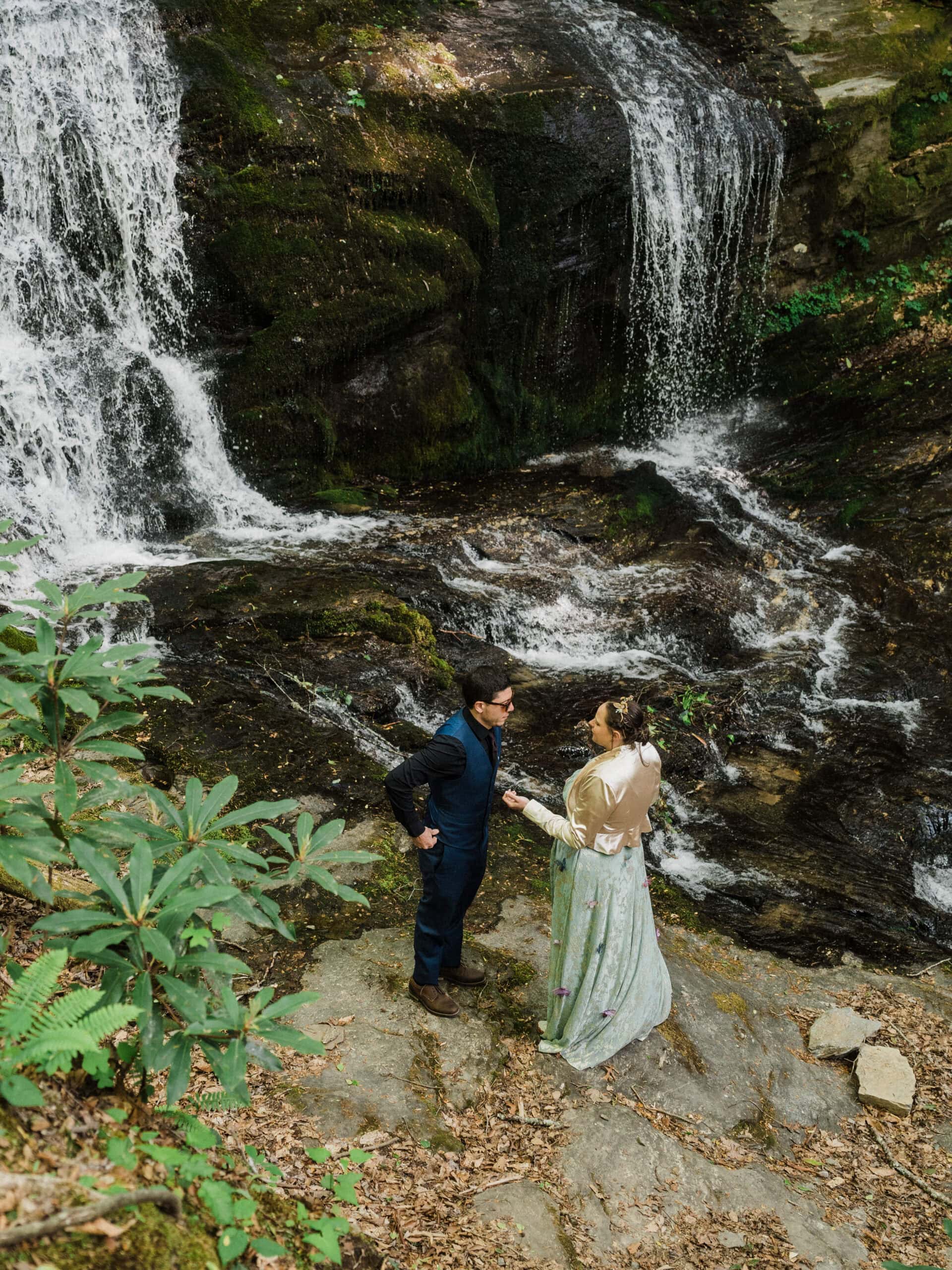 couple exchanging private vows in front of a waterfall during their blue ridge parkway elopement day