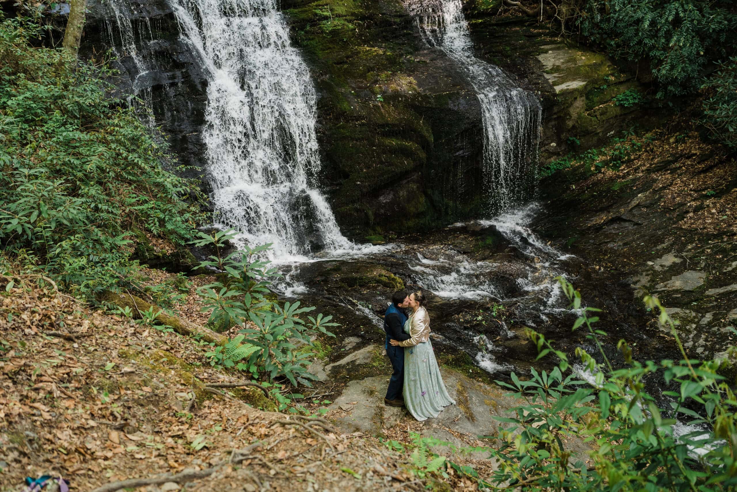 couple exchanging private vows in front of a waterfall during their blue ridge parkway elopement day