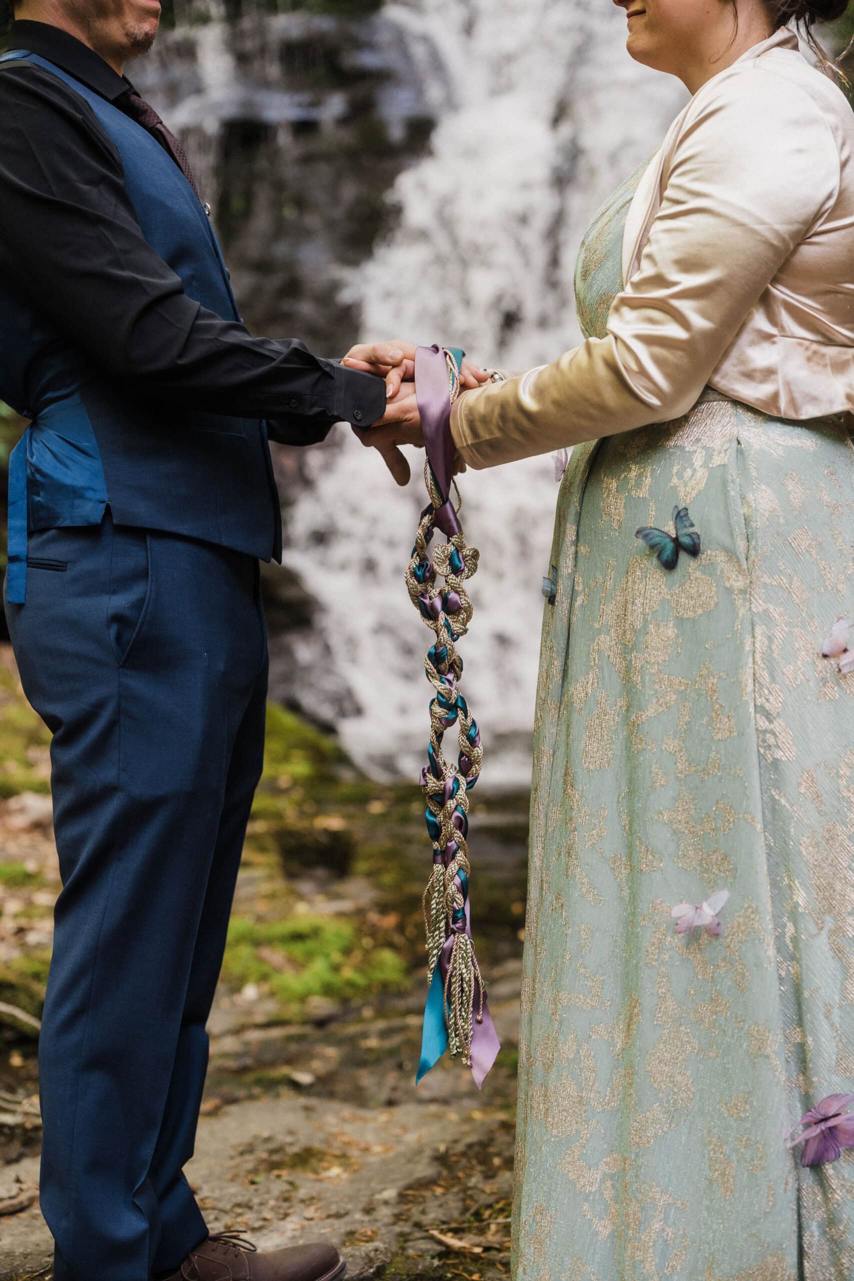 couple exchanging private vows in front of a waterfall during their blue ridge parkway elopement day