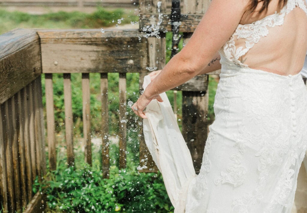 elopement couple rinsing off their feet at a shower in florida