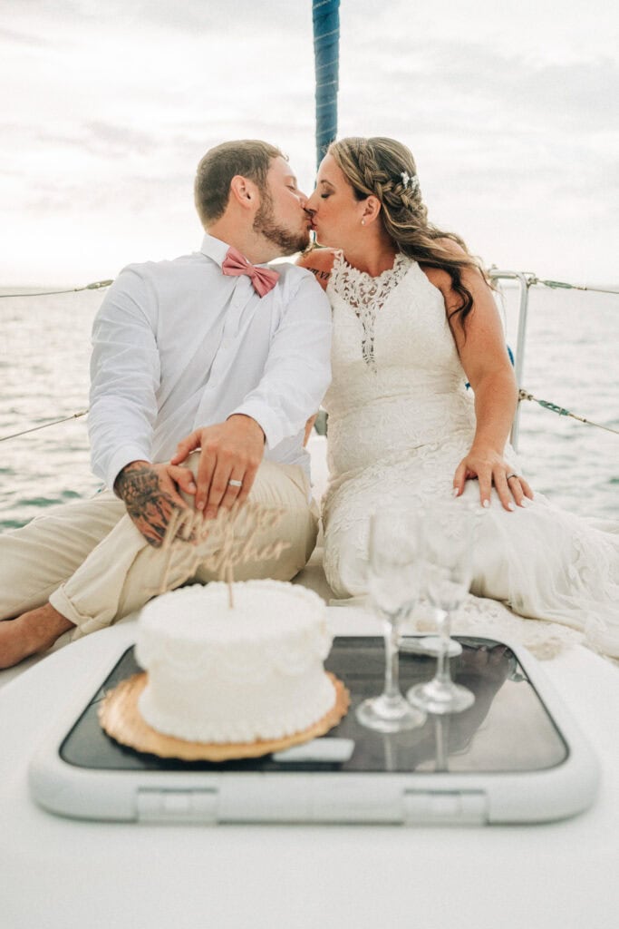 elopement couple with their cake on a sailboat during their florida sailboat elopement day