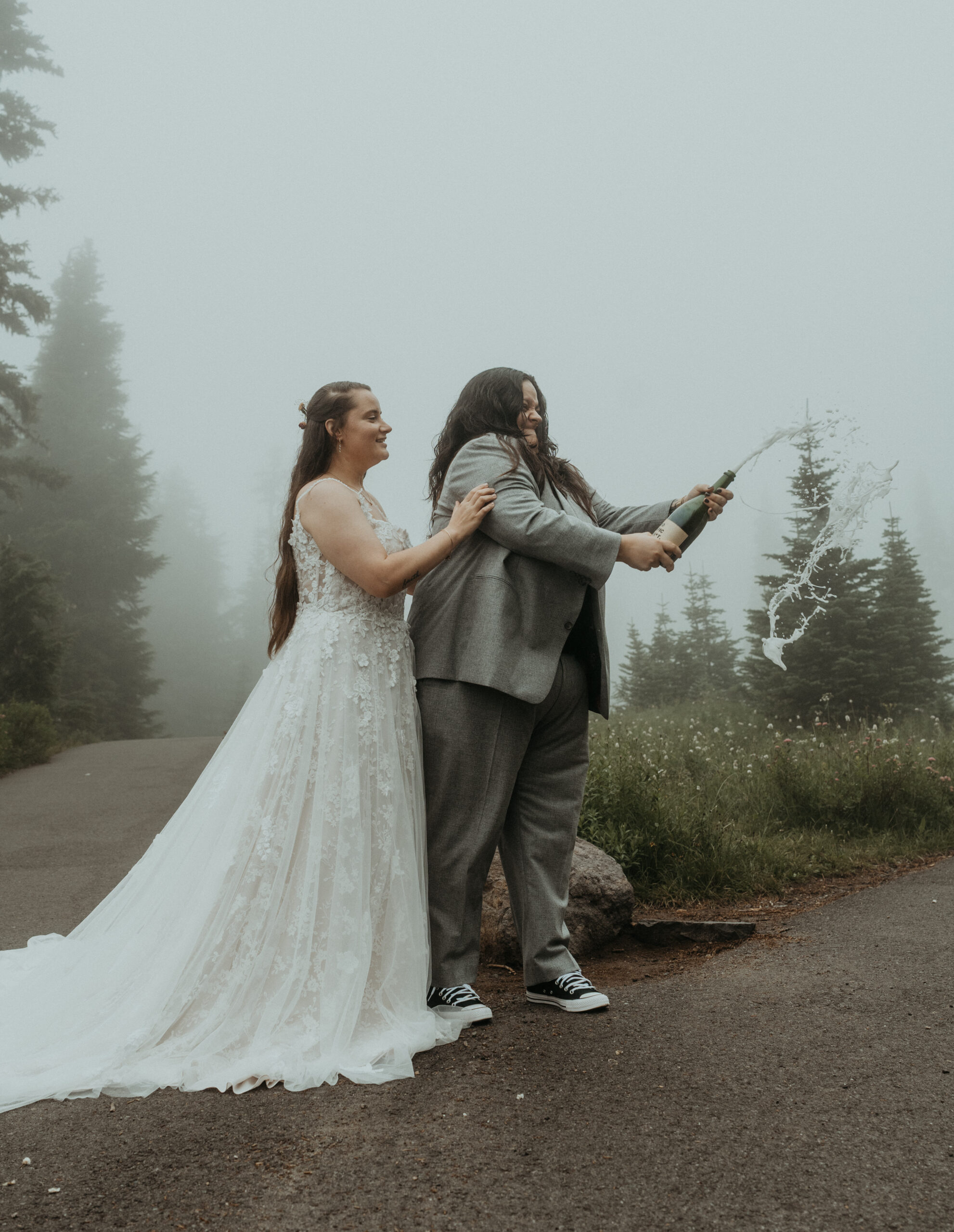 elopement couple popping champagne during their mt rainier wildflower elopement