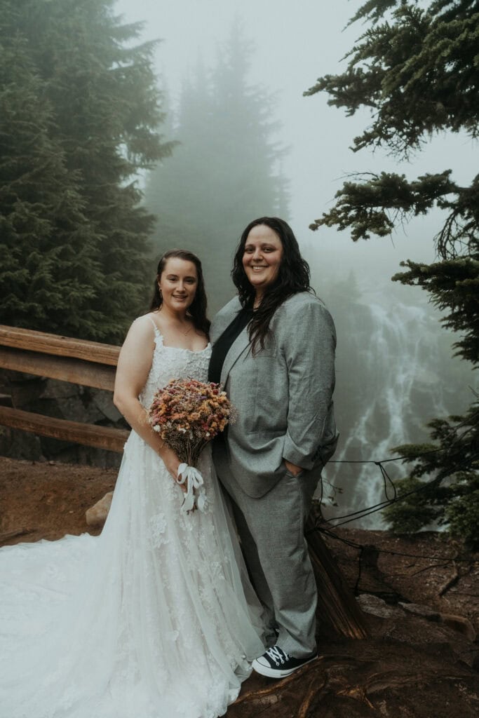 elopement couple in front of a waterfall during their mt rainier wildflower elopement