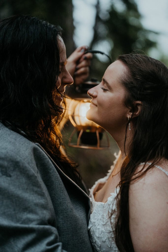 elopement couple holding lanterns during their moody elopement in mt rainier national park